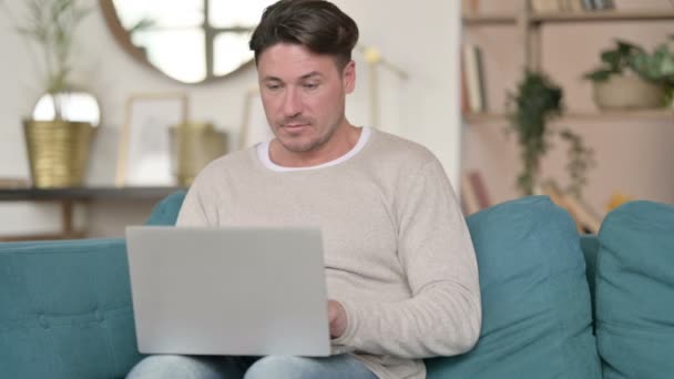 Mężczyzna w średnim wieku opuszcza laptop i odchodzi, w domu — Wideo stockowe