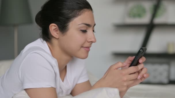 Молода індійська жінка користується смартфоном у ліжку — стокове відео