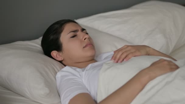 Mujer india joven con tos acostada en la cama — Vídeo de stock