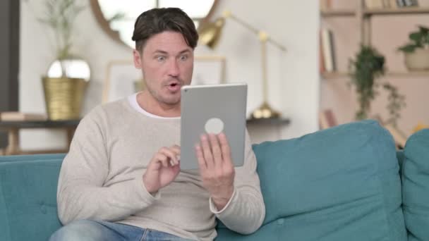 Homem de meia-idade comemorando em Tablet, em casa — Vídeo de Stock