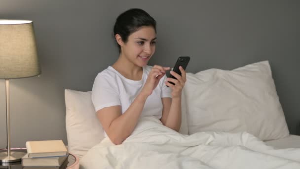 Succès, Femme indienne Célébrant sur Smartphone au lit — Video