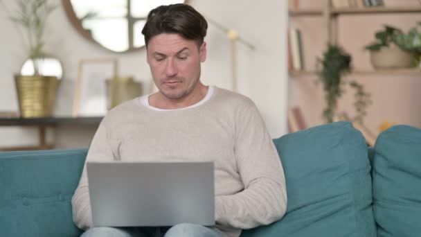 Laptop pracy przez średniowiecznego człowieka z bólem szyi w domu — Wideo stockowe