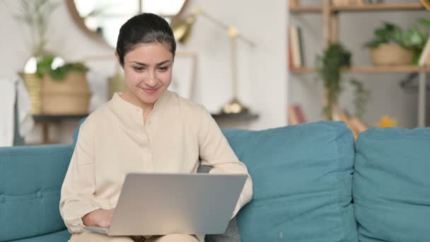 Giovane donna indiana di successo con computer portatile che celebra sul divano — Video Stock