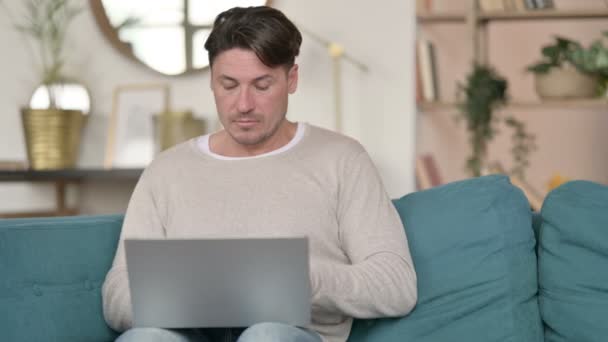 Mężczyzna w średnim wieku z laptopem o ból nadgarstka w domu — Wideo stockowe