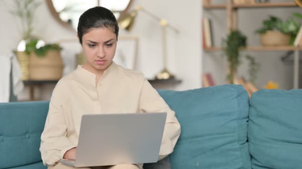 Travail d'ordinateur portable par jeune femme indienne avec douleur au cou sur le canapé — Video