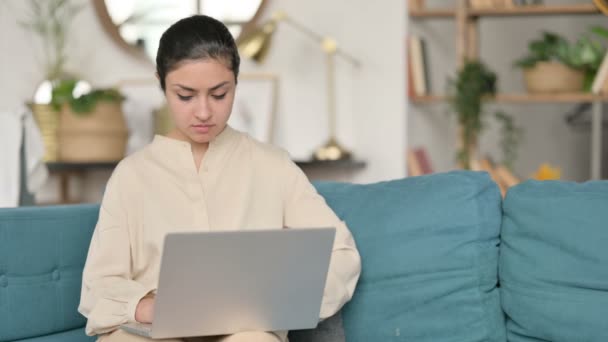 Młoda Hinduska kobieta z laptopem mając ból nadgarstka na kanapie — Wideo stockowe