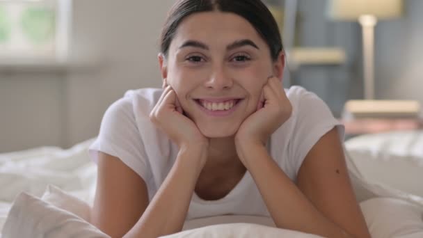 Yatakta uzanan Latin Kadın Kameraya gülümsüyor — Stok video