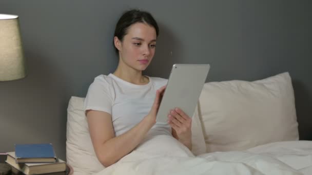 Atrakcyjne młoda kobieta za pomocą tabletki w łóżku — Wideo stockowe