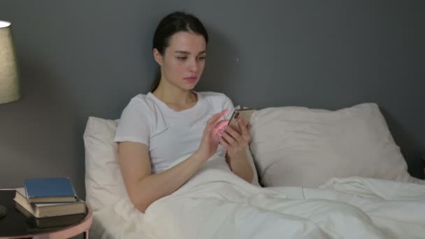 Yatakta Genç Kadın 'ın akıllı telefon kullanımı — Stok video