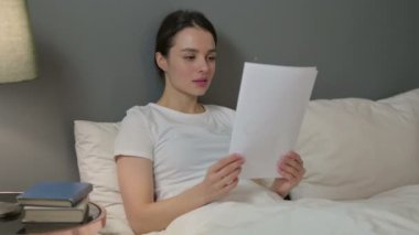 Yataktaki Belgelerde Başarıyı Kutlayan Genç Kadın 