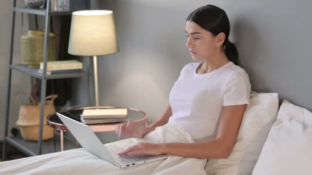 Donna latina con computer portatile con dolore al collo a letto — Video Stock