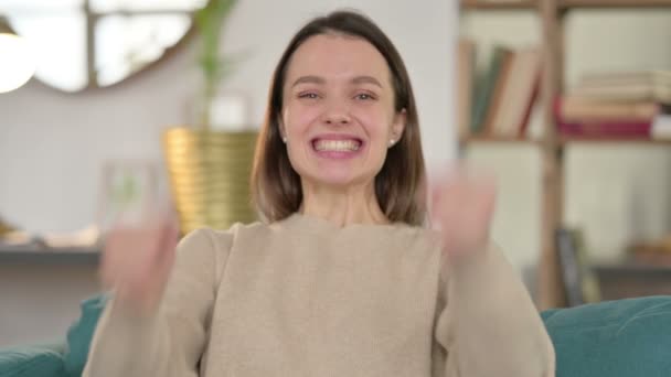 Porträt einer aufgeregten jungen Frau, die zu Hause feiert — Stockvideo