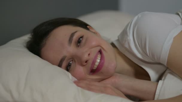 Yatakta Kameraya Gülümseyen Genç Kadın 'ın yakın çekimi — Stok video
