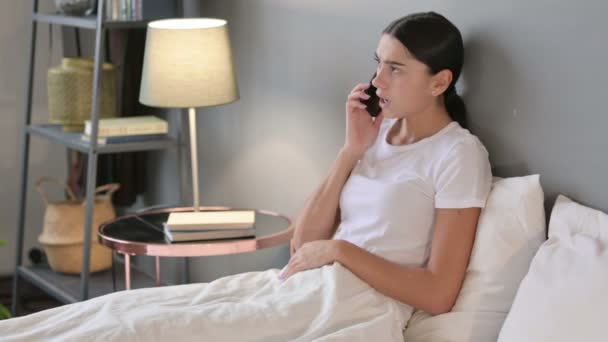 Wściekła Latynoska rozmawiająca na smartfonie w łóżku — Wideo stockowe