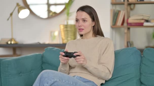 Giovane donna che ha la perdita sul videogioco sul divano — Video Stock