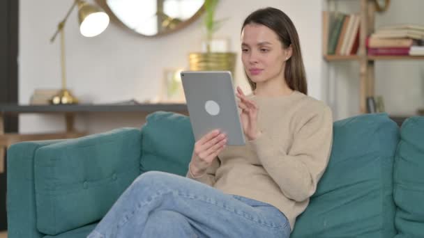 Młoda kobieta za pomocą tabletu na kanapie — Wideo stockowe