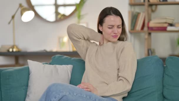 Fatigué jeune femme avec douleur au cou assis sur le canapé — Video
