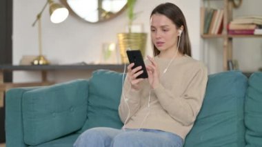 Genç Kadın Kanepede Smartphone kullanarak meditasyon yapıyor