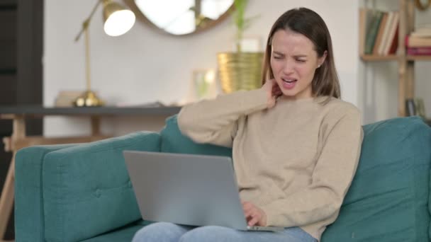Laptop Praca przez młodą kobietę z bólem szyi na kanapie — Wideo stockowe