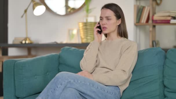 Fiatal nő dühös Smartphone a kanapén — Stock videók