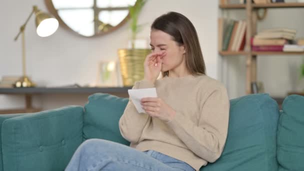 Kranke junge Frau niest auf Sofa — Stockvideo