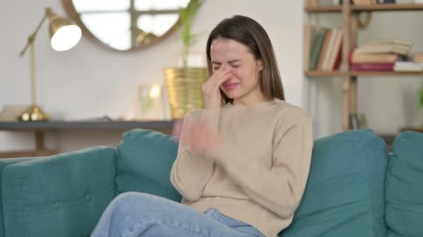 Ung kvinna sitter och gråter på soffan — Stockvideo