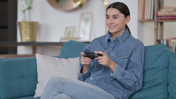 Приваблива латинська жінка грає у відеоігри на Софі — стокове відео