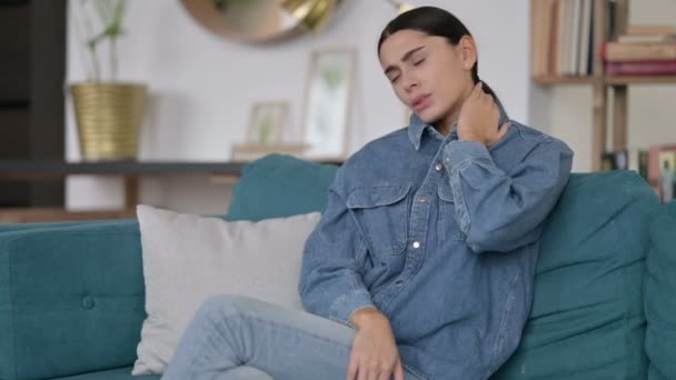 Fáradt latin nő nyaki fájdalom ül a kanapén — Stock videók