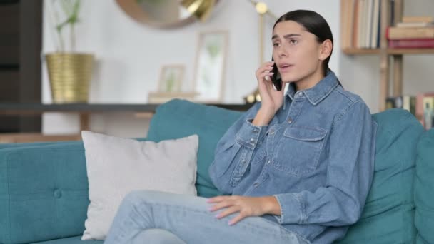 Latina mulher irritada no smartphone no sofá — Vídeo de Stock