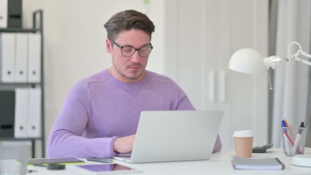 Kreatywny mężczyzna w średnim wieku z trzęsącą się głową na laptopie, tak — Wideo stockowe
