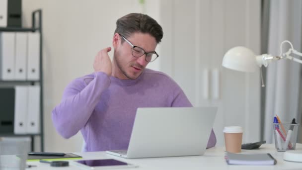 Kreativer Mann mittleren Alters mit Laptop hat Nackenschmerzen im Büro — Stockvideo