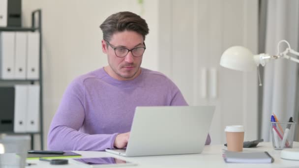 Kreativer Mann mittleren Alters trinkt Kaffee bei der Arbeit — Stockvideo