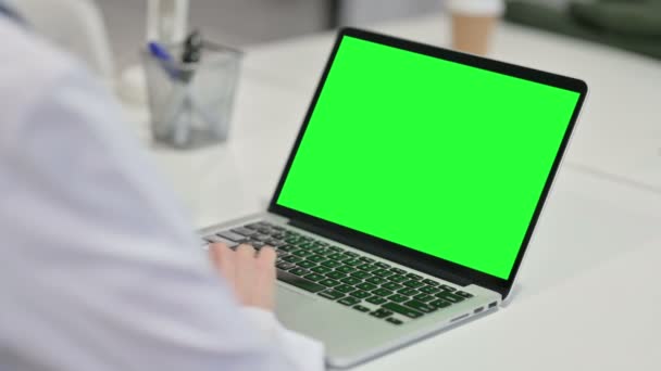 Πίσω όψη της νεαρής γυναίκας που χρησιμοποιεί φορητό υπολογιστή με οθόνη Chroma — Αρχείο Βίντεο