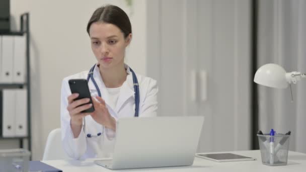 Jovem Médica com Laptop usando Smartphone — Vídeo de Stock