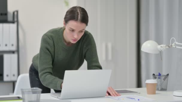 Junge Frau steht am Laptop und arbeitet — Stockvideo