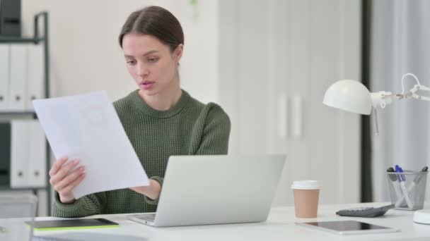 Jonge vrouw met laptop werkt aan documenten — Stockvideo