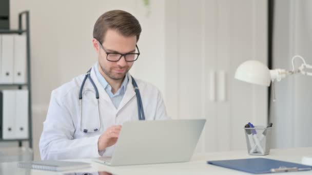 Ung manlig läkare med bärbar dator har huvudvärk i Office — Stockvideo