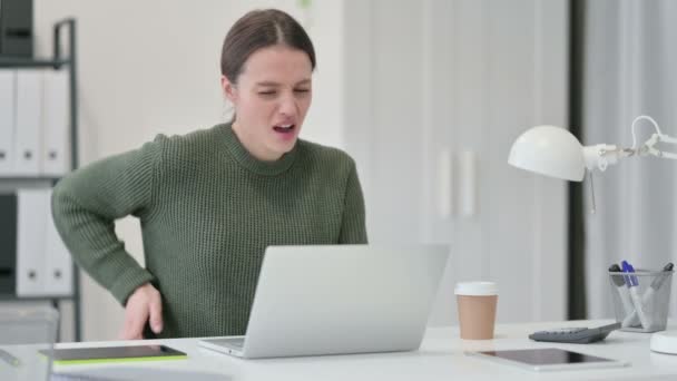 Jonge vrouw met laptop met rugpijn — Stockvideo