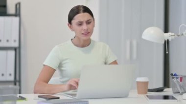 Dizüstü bilgisayarlı, boynu ağrıyan genç Latin Kadın. 