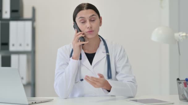 Женщина-врач разговаривает по телефону в клинике — стоковое видео