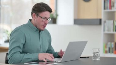 Dizüstü bilgisayar kullanırken Orta Yaşlı Adam Başarı Kutlaması 