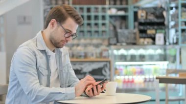 Kafe 'de akıllı telefon kullanan yaratıcı adam.