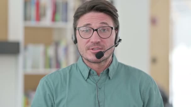 Hombre de mediana edad hablando en auriculares — Vídeo de stock