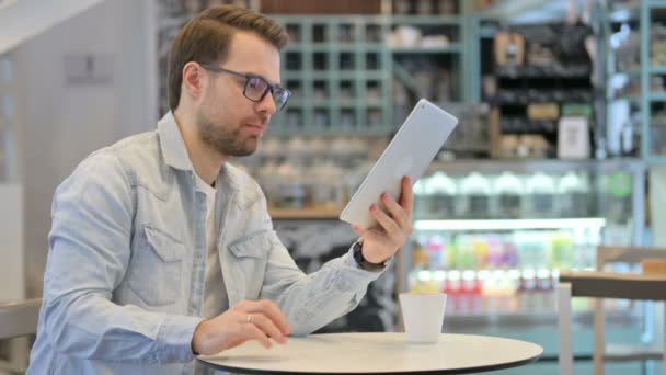 Erfolgreicher Kreativer feiert auf Tablet im Café — Stockvideo