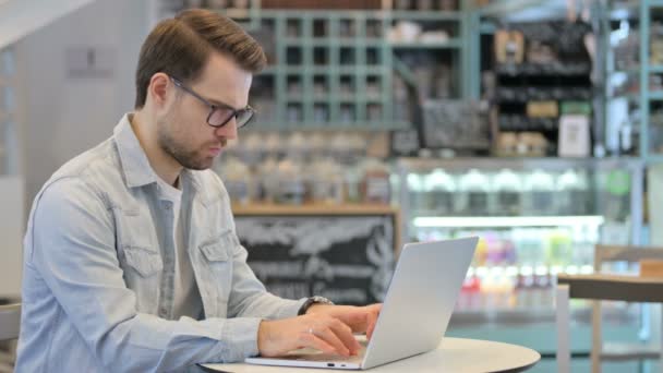 Hombre creativo pensando mientras usa el ordenador portátil en el Café — Vídeos de Stock