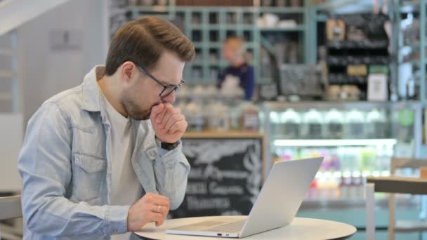 Hombre creativo tosiendo mientras trabaja en el ordenador portátil — Vídeo de stock