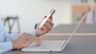 Akıllı telefon ve dizüstü bilgisayar kullanan Afrikalı adam, kapat 