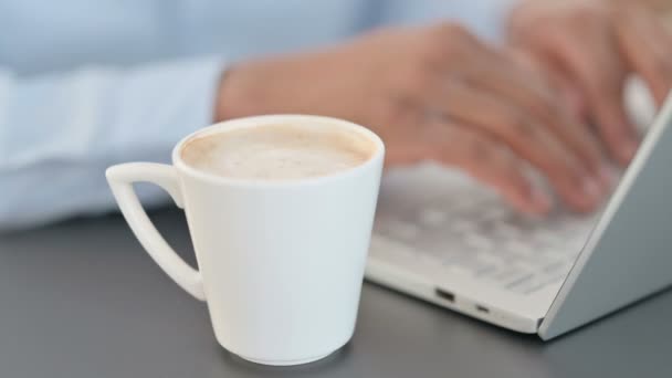 Primer plano del hombre que bebe café mientras usa el ordenador portátil — Vídeo de stock