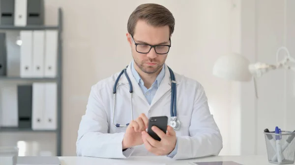 Mężczyzna lekarz za pomocą smartfona w biurze — Zdjęcie stockowe