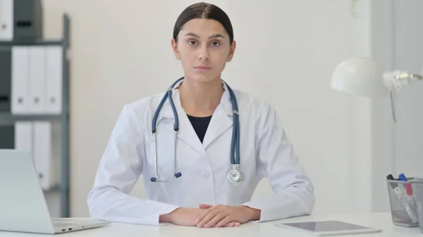 Serieuze vrouwelijke arts in de kliniek kijken naar de camera — Stockfoto